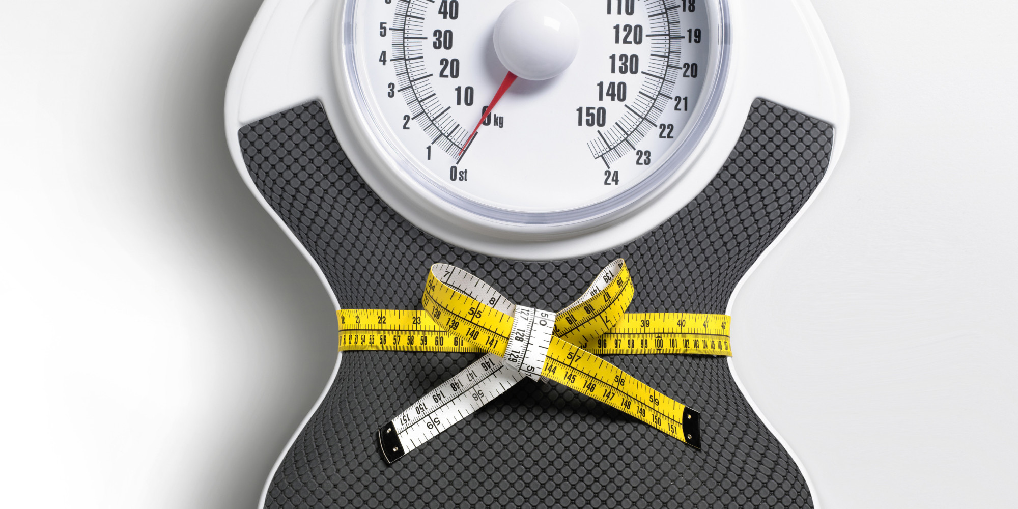 White grey weight scale with measuring tape around it