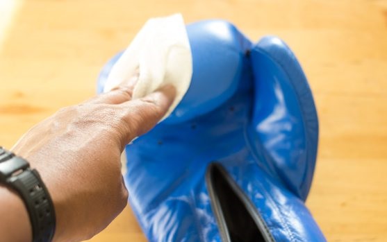 hand cleaning blue boxing glove with cloth