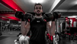 Man using dumbbells for muscle building at gym