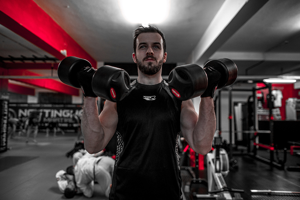 Man using dumbbells for muscle building at gym