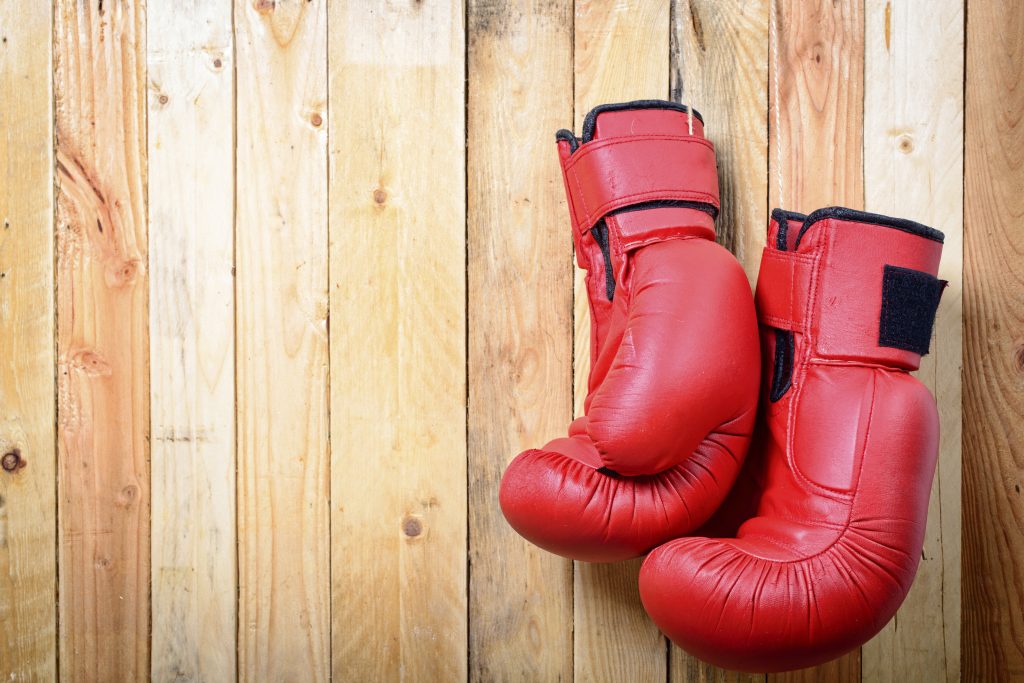 Pair of red boxing gloves hanging on wall